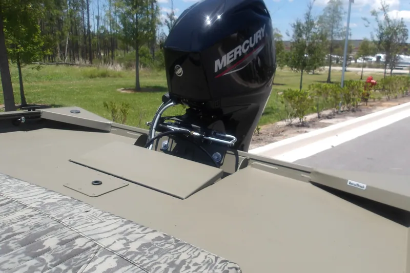 Slide: The Image of 2026 Tracker Grizzly 1860 CC boat with Mercury outboard motor in a park setting. - 13
