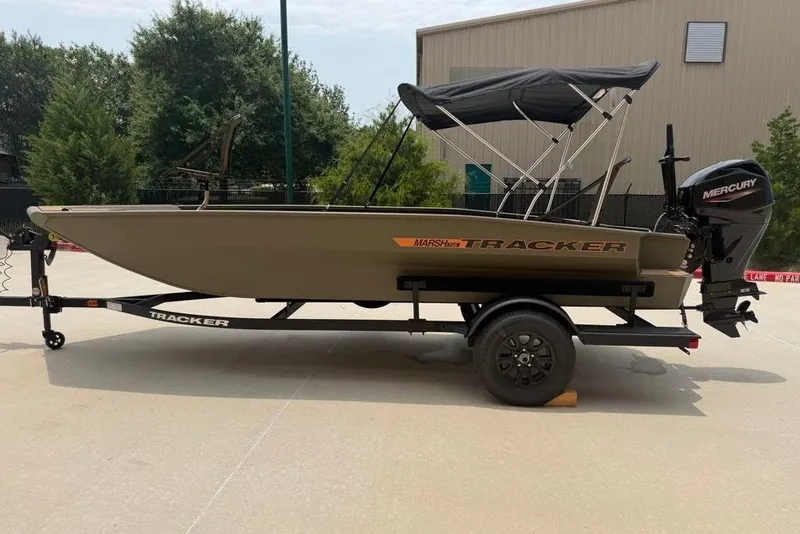 The Image of 2026 Tracker Grizzly 1756 T Marsh boat on trailer, featuring a Mercury outboard motor. - 0