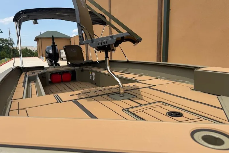 Slide: The Image of 2026 Tracker Grizzly 1756 T Marsh boat interior with seating and motor, showcasing spacious deck design. - 14