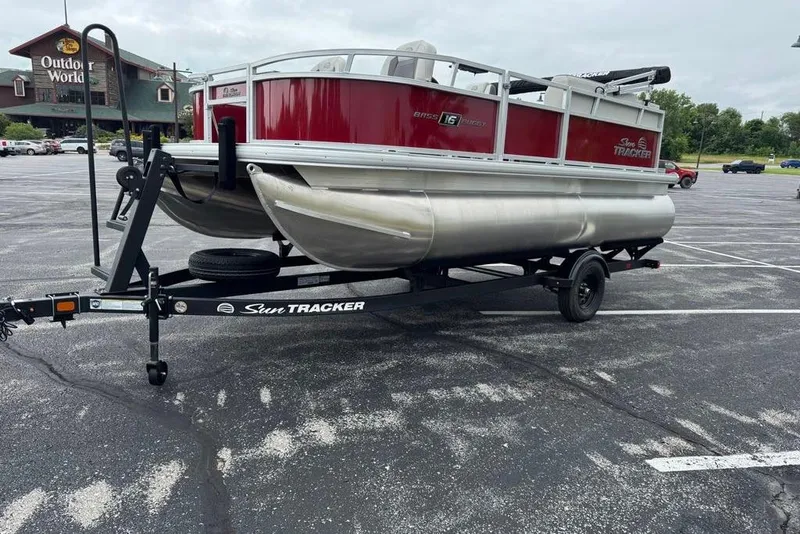 Slide: The Image of 2026 Sun Tracker Bass Buggy 16 XL Select pontoon boat on trailer in parking lot. - 4