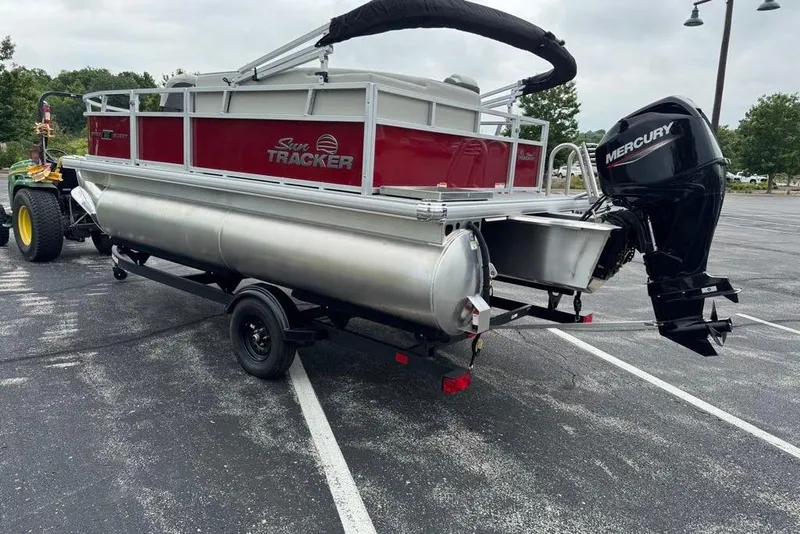 Slide: The Image of 2026 Sun Tracker Bass Buggy 16 XL Select pontoon boat with Mercury outboard motor in parking lot. - 5
