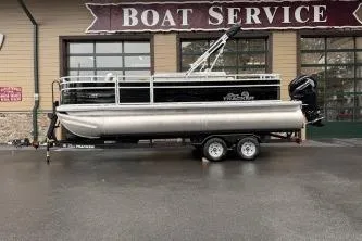 The Image of 2026 Sun Tracker Fishin' Barge 20 DLX pontoon boat on trailer at boat service center. - 0