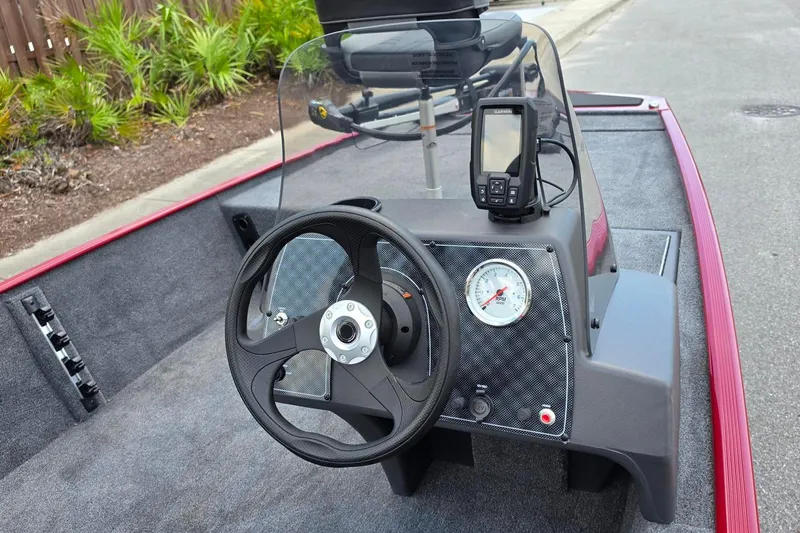 Slide: The Image of 2026 Tracker Bass Tracker Classic XL boat dashboard with steering wheel and GPS device. - 12