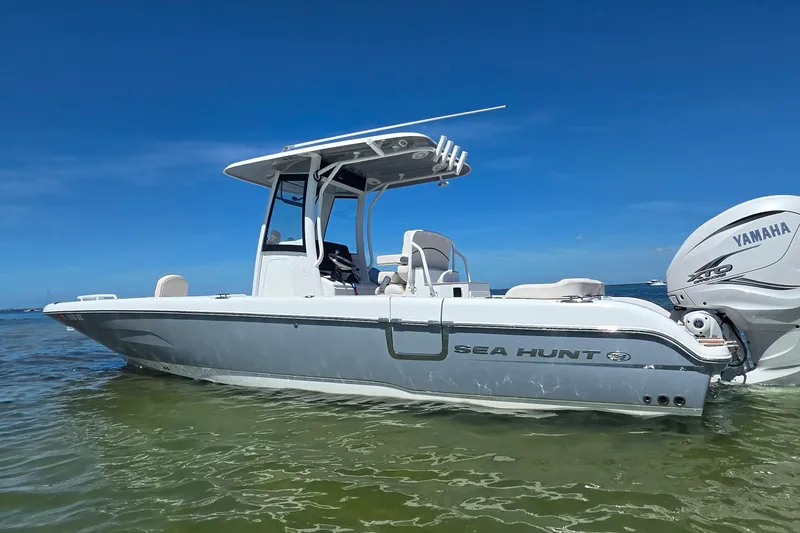 Slide: The Image of 2021 Sea Hunt Escape 27 boat with Yamaha engine on calm water under clear blue sky. - 10