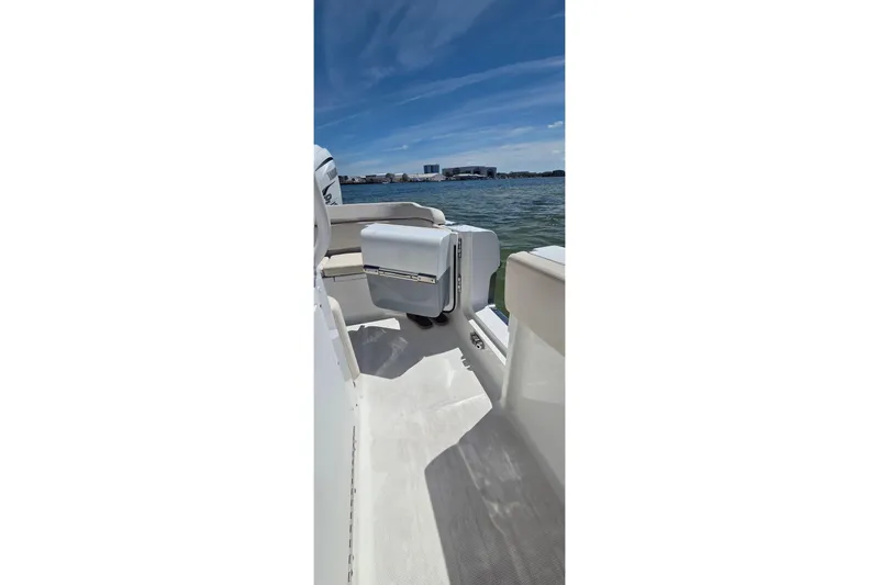 Slide: The Image of 2021 Sea Hunt Escape 27 boat interior with seating, on a sunny day by the water. - 12