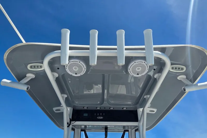 Slide: The Image of T-top of 2021 Sea Hunt Escape 27 boat with rod holders and speakers against blue sky. - 22