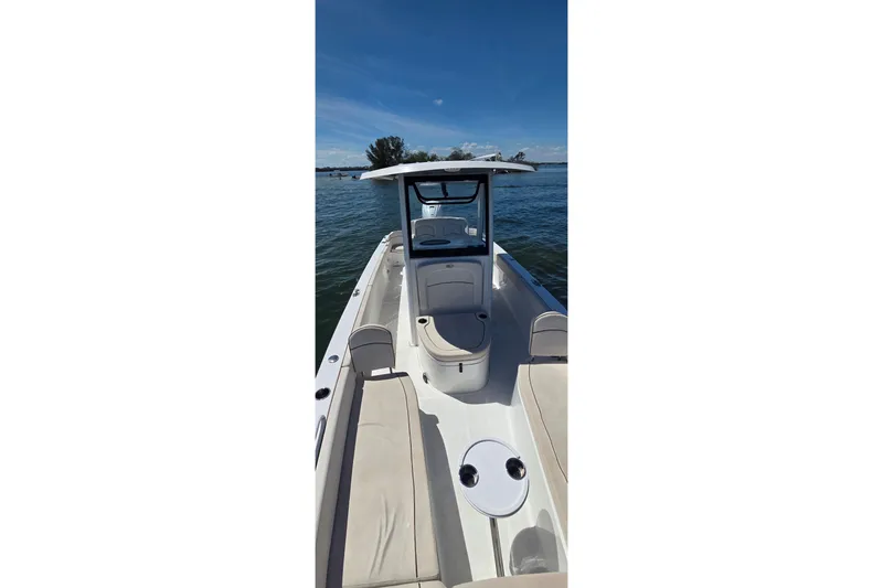 Slide: The Image of 2021 Sea Hunt Escape 27 boat on water, featuring spacious deck and seating. - 25