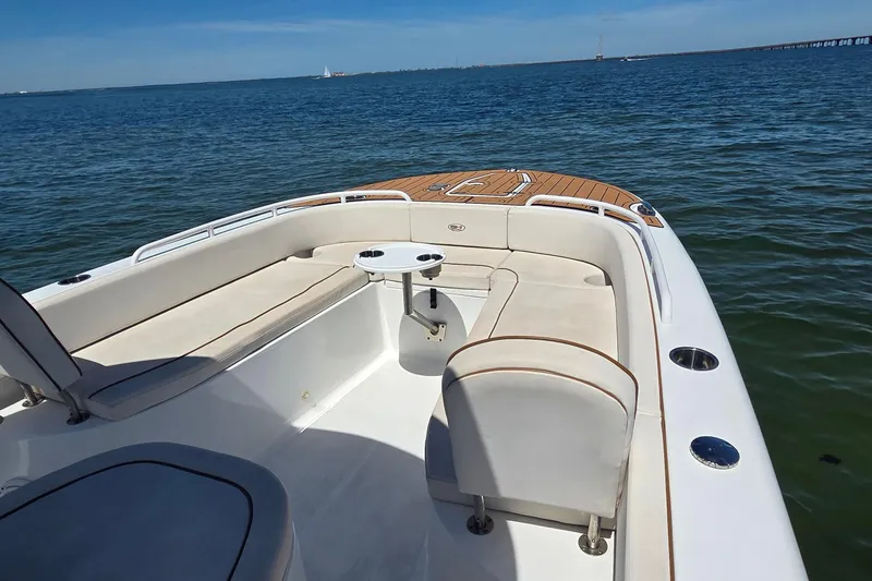 Slide: The Image of 2021 Sea Hunt Escape 27 boat interior with seating and table on calm water. - 3