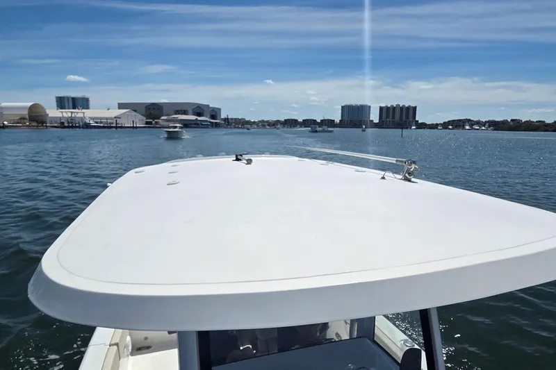 Slide: The Image of 2021 Sea Hunt Escape 27 boat cruising on a sunny day in a marina. - 9