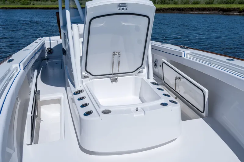 Slide: The Image of 2027 Valhalla Boatworks V-29 Hybrid deck with open storage compartment, surrounded by water. - 24