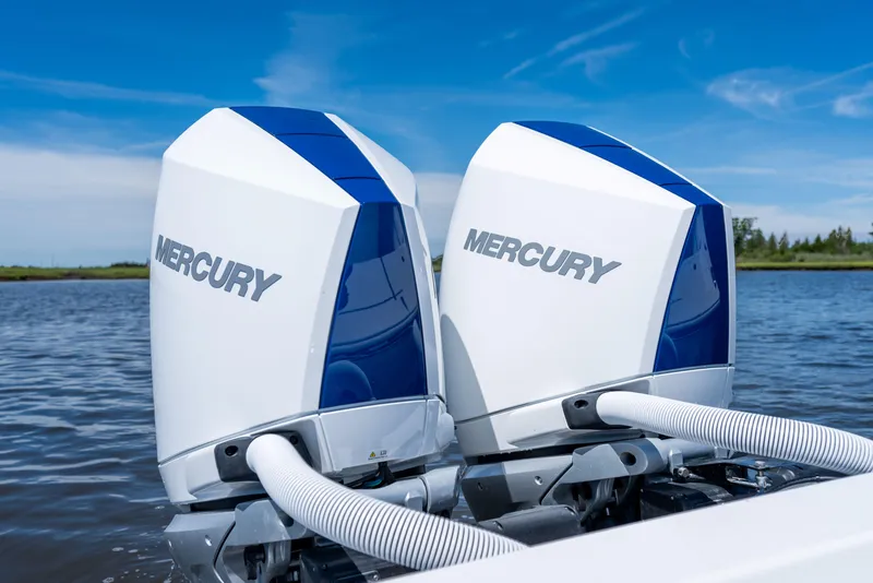Slide: The Image of Twin Mercury outboard engines on a 2027 Valhalla Boatworks V-29 Hybrid, on a serene waterway. - 42