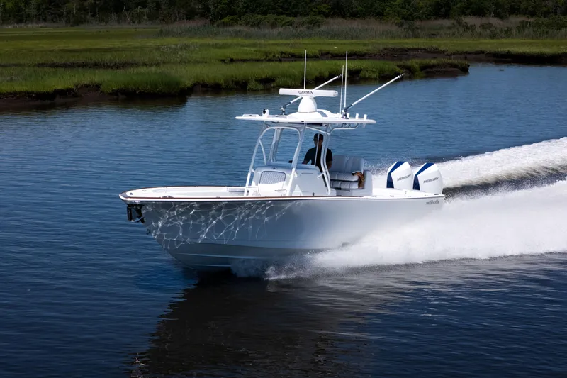 Slide: The Image of 2027 Valhalla Boatworks V-29 Hybrid cruising on a serene waterway. - 8
