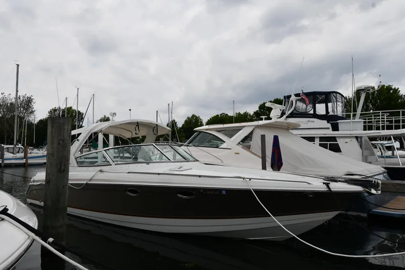 The Image of 2004 Formula 330 Sun Sport boat docked at a marina under cloudy skies. - 1