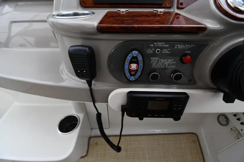 Slide: The Image of 2004 Formula 330 Sun Sport dashboard with controls, microphone, and Garmin device. - 13