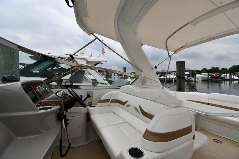 Slide: The Image of 2004 Formula 330 Sun Sport boat interior at marina, featuring white seating and helm. - 15
