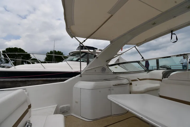 Slide: The Image of 2004 Formula 330 Sun Sport boat interior with seating and table under canopy. - 17