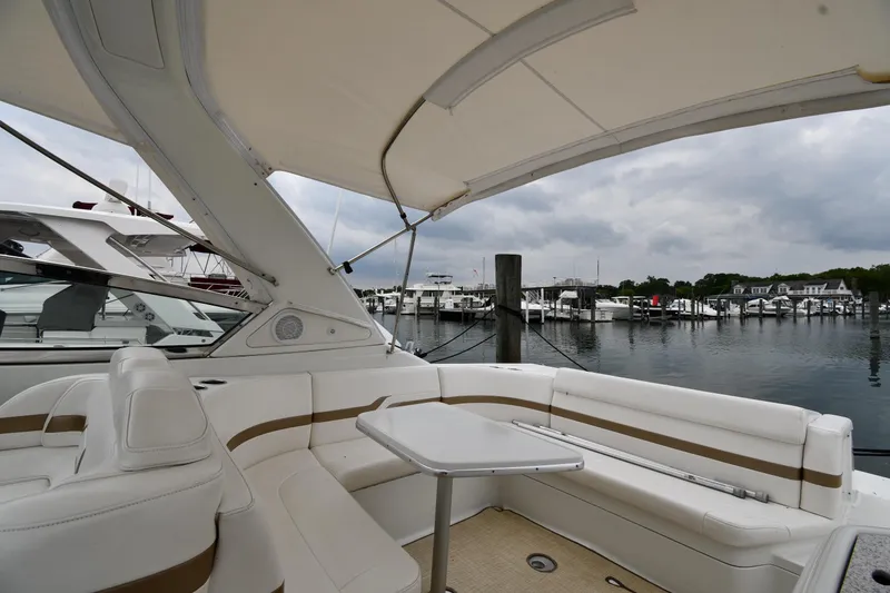 Slide: The Image of 2004 Formula 330 Sun Sport boat interior with marina view, featuring white seating and table. - 18