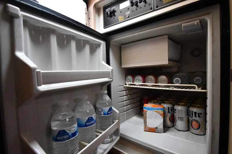 Slide: The Image of Mini fridge stocked with drinks and water bottles on a 2004 Formula 330 Sun Sport boat. - 35