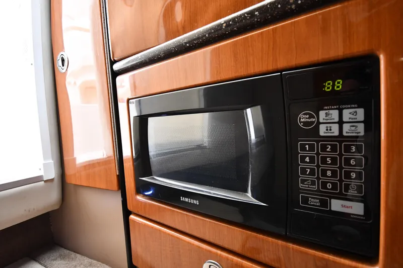 Slide: The Image of Microwave in 2004 Formula 330 Sun Sport boat interior, featuring wood paneling and digital controls. - 37