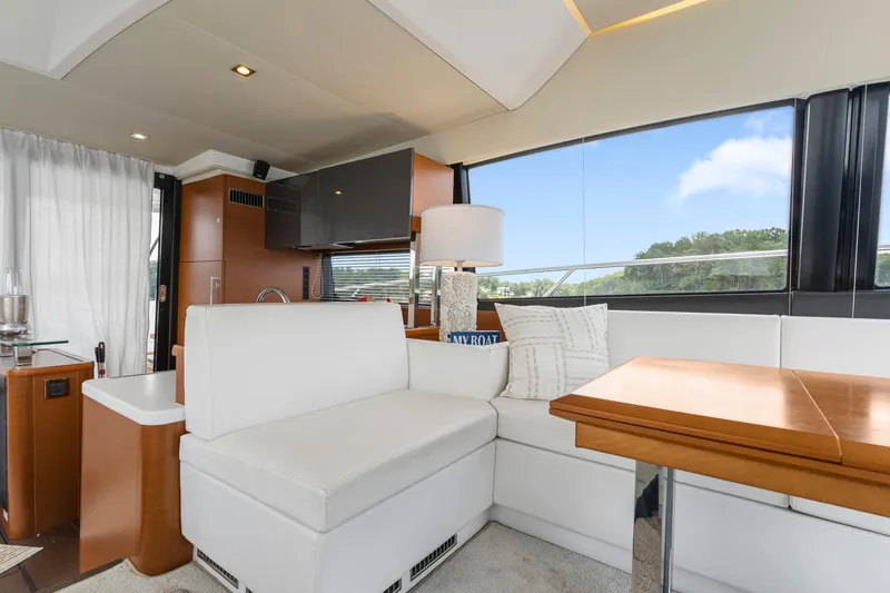 Slide: The Image of Luxurious interior of a 2017 Prestige 500 yacht with white seating and wooden table. - 16