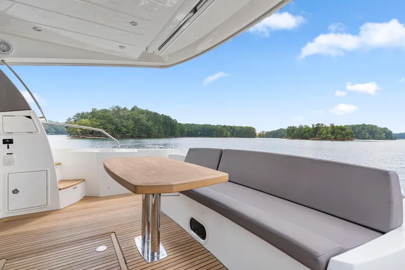 Slide: The Image of Luxury yacht deck with seating and table, overlooking serene lake and lush greenery. Prestige 500, 2017. - 30