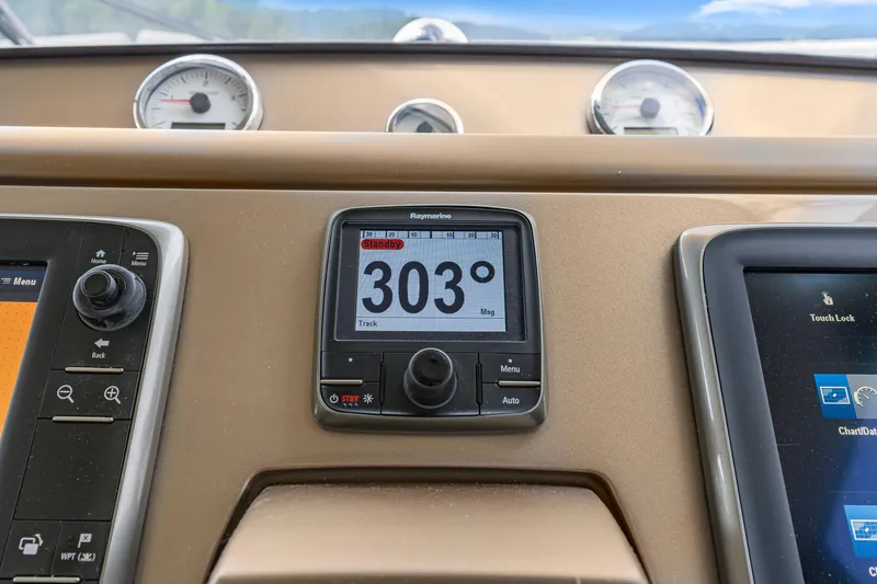 Slide: The Image of Boat dashboard with navigation instruments, featuring a Raymarine display showing 303 degrees. Prestige 500, 2017. - 47