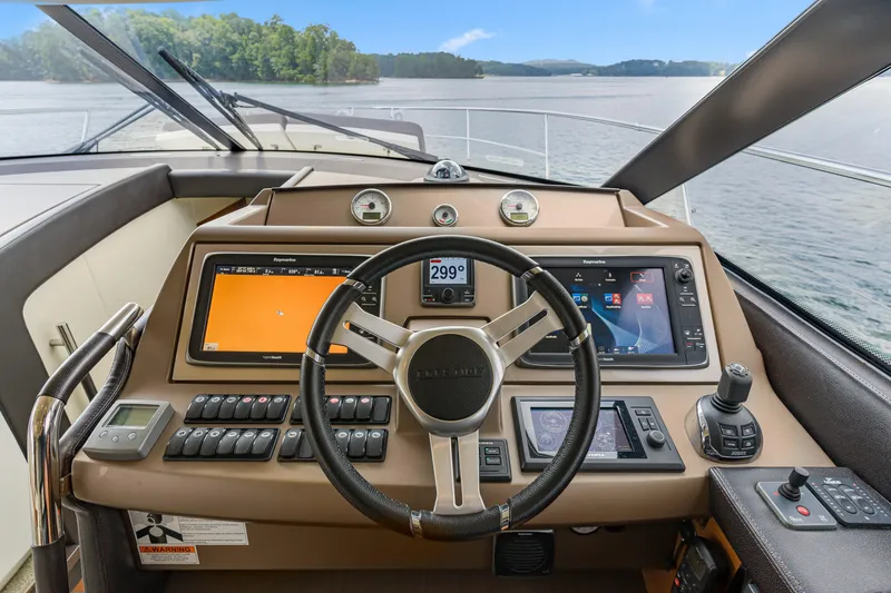 Slide: The Image of Cockpit of 2017 Prestige 500 yacht with advanced navigation controls and scenic water view. - 50