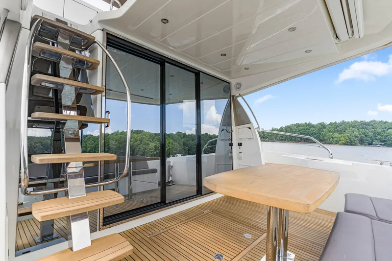 Slide: The Image of Luxurious 2017 Prestige 500 yacht interior with wooden deck, modern staircase, and scenic water view. - 52