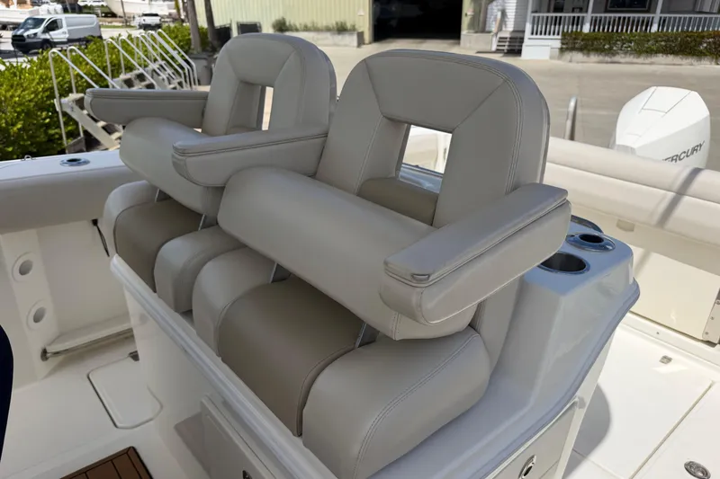 Slide: The Image of 2019 Boston Whaler 280 Outrage boat seats with armrests and cup holders. - 17