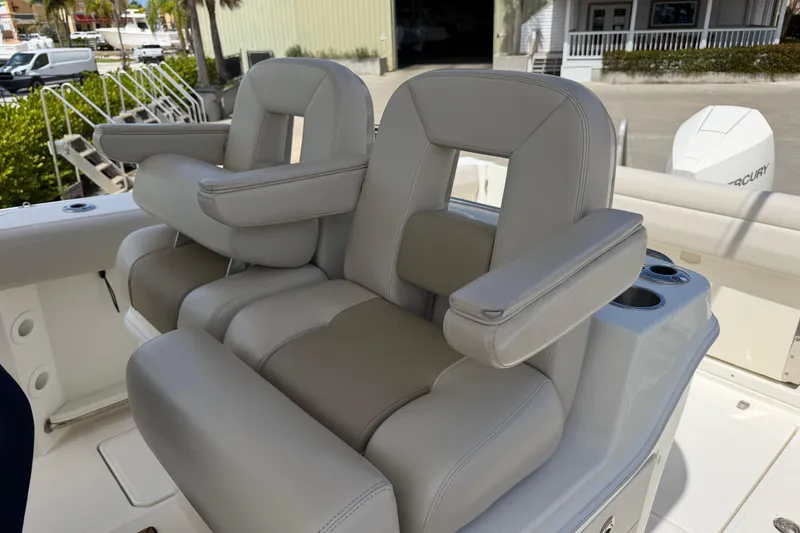 Slide: The Image of 2019 Boston Whaler 280 Outrage boat seats with armrests and cup holders. - 18
