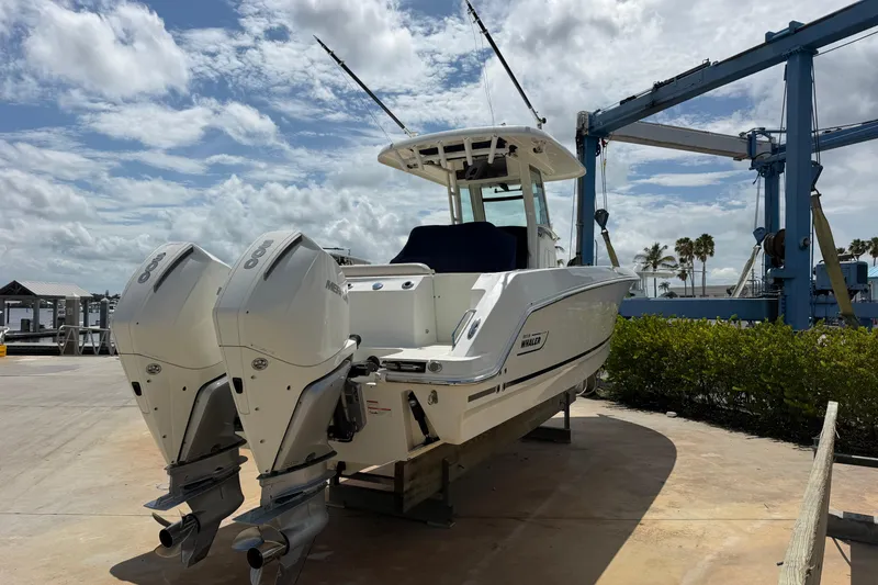 Slide: The Image of 2019 Boston Whaler 280 Outrage boat with dual engines on a sunny dock. - 2