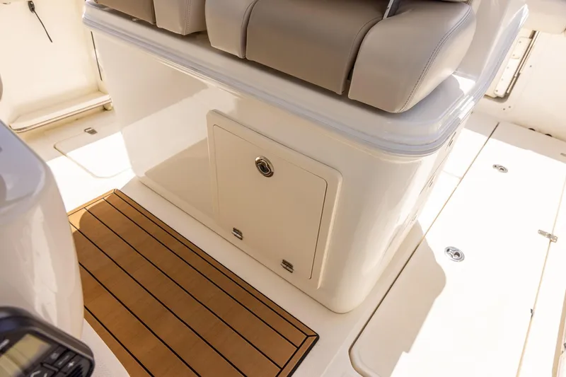Slide: The Image of 2019 Boston Whaler 280 Outrage interior with cushioned seating and storage compartment. - 25