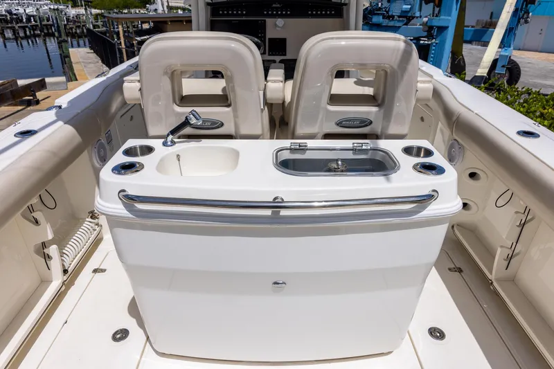Slide: The Image of 2019 Boston Whaler 280 Outrage boat interior with sink and seating area. - 17