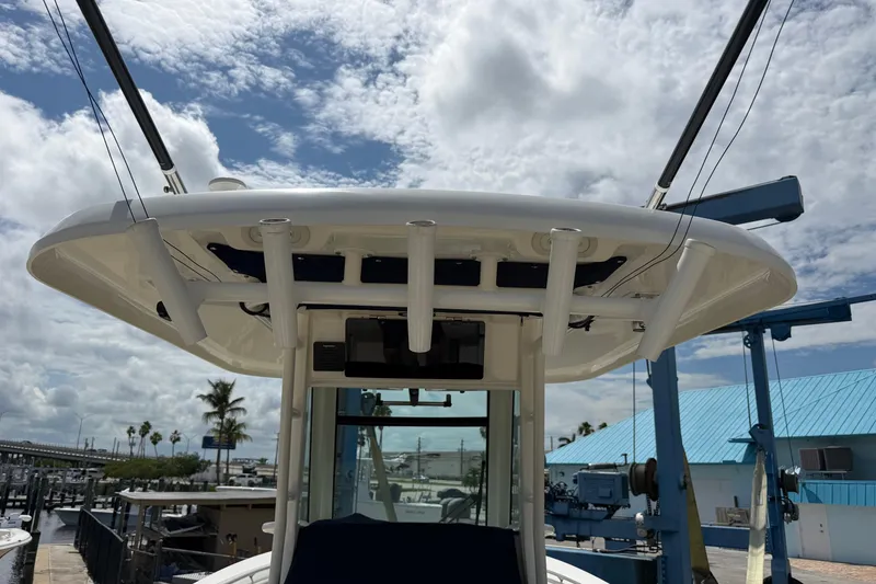 Slide: The Image of 2019 Boston Whaler 280 Outrage boat with fishing rod holders, docked under a cloudy sky. - 27