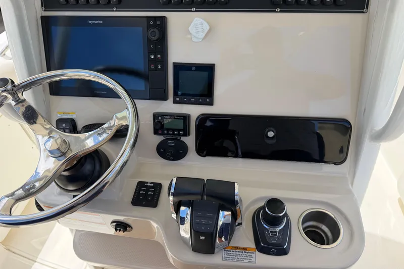 Slide: The Image of Control panel of a 2019 Boston Whaler 280 Outrage boat with steering wheel and navigation equipment. - 29