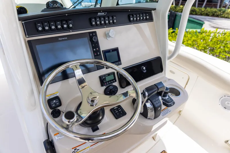 Slide: The Image of Control panel of 2019 Boston Whaler 280 Outrage boat with steering wheel and navigation equipment. - 11