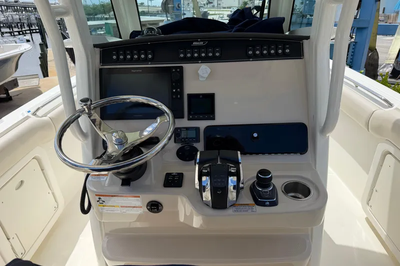 Slide: The Image of 2019 Boston Whaler 280 Outrage helm with steering wheel and control panel. - 30