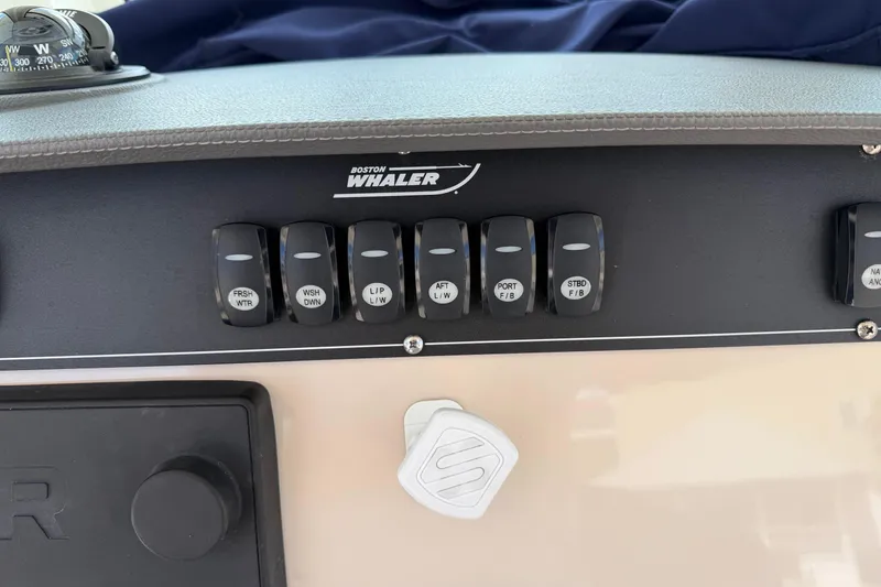 Slide: The Image of Control panel of a 2019 Boston Whaler 280 Outrage boat with labeled switches. - 33