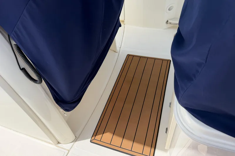 Slide: The Image of Interior view of a 2019 Boston Whaler 280 Outrage boat with blue covers and wooden flooring. - 53
