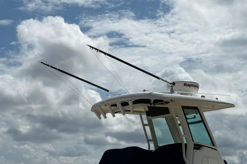 Slide: The Image of Boston Whaler 280 Outrage 2019 boat with radar and outriggers against cloudy sky. - 55