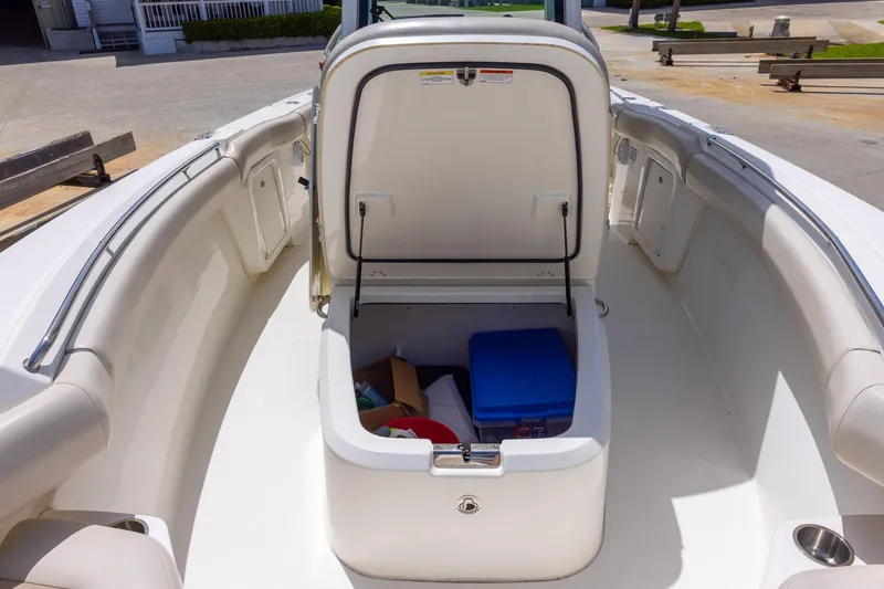 Slide: The Image of 2019 Boston Whaler 280 Outrage boat with open storage compartment, docked outdoors. - 27