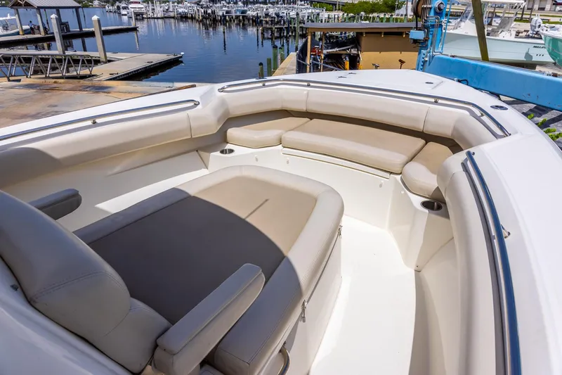 Slide: The Image of 2019 Boston Whaler 280 Outrage boat interior with cushioned seating at marina. - 29