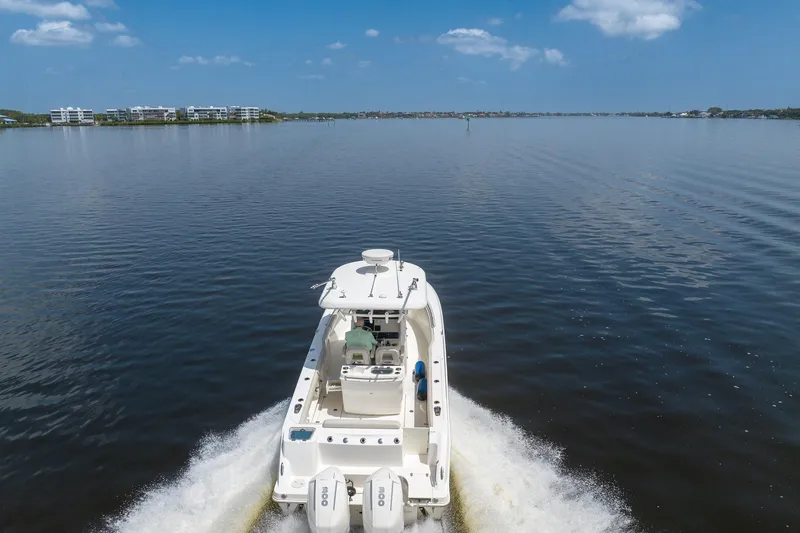 Slide: The Image of 2019 Boston Whaler 280 Outrage cruising on a calm lake under a clear blue sky. - 3