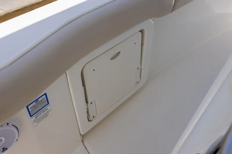 Slide: The Image of 2019 Boston Whaler 280 Outrage interior storage compartment with speaker and safety label. - 21