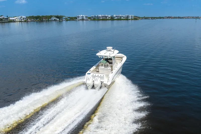 Slide: The Image of 2019 Boston Whaler 280 Outrage cruising on a calm lake with scenic shoreline. - 1