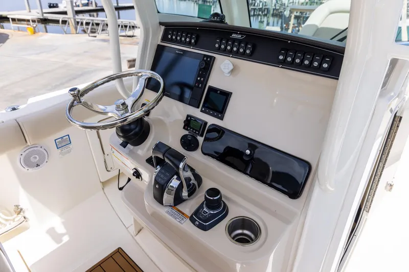 Slide: The Image of 2019 Boston Whaler 280 Outrage helm with steering wheel and control panel. - 12