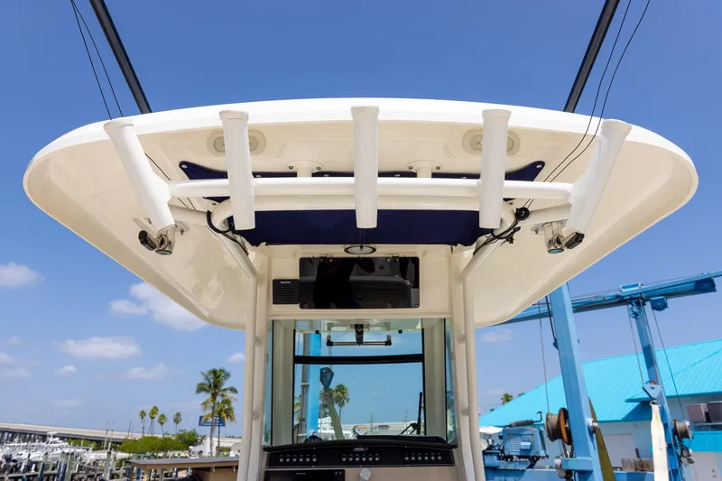 Slide: The Image of 2019 Boston Whaler 280 Outrage boat, featuring rod holders and a sleek design under a clear blue sky. - 35