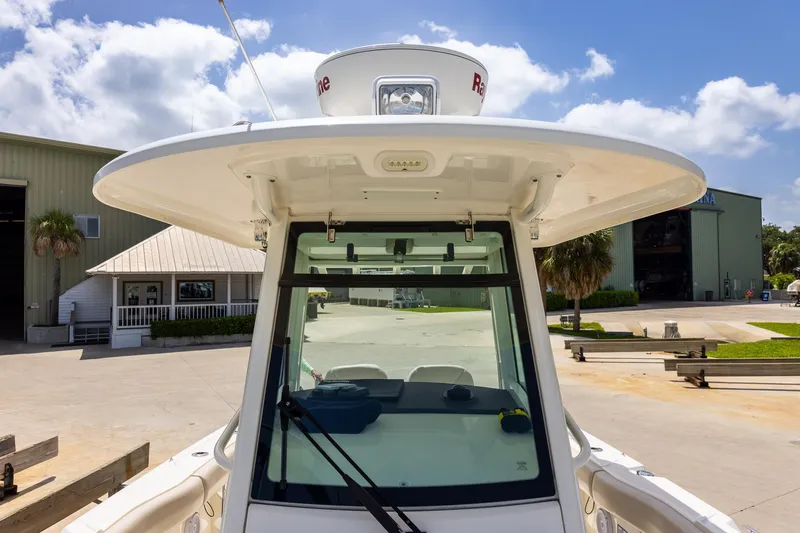 Slide: The Image of 2019 Boston Whaler 280 Outrage boat docked, showcasing helm and radar, under sunny skies. - 32