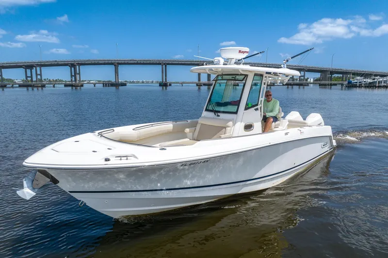 The Image of 2019 Boston Whaler 280 Outrage boat cruising on a sunny day near a bridge. - 4
