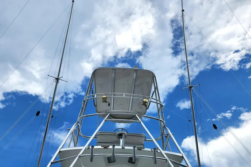 Slide: The Image of 1987 Young Brothers Custom Sport Fish boat against a vibrant blue sky with clouds. - 12